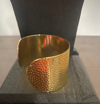 Gold textured cuff on a wooden block