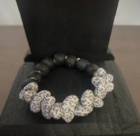 Black and white beaded bracelet on a dark wooden block