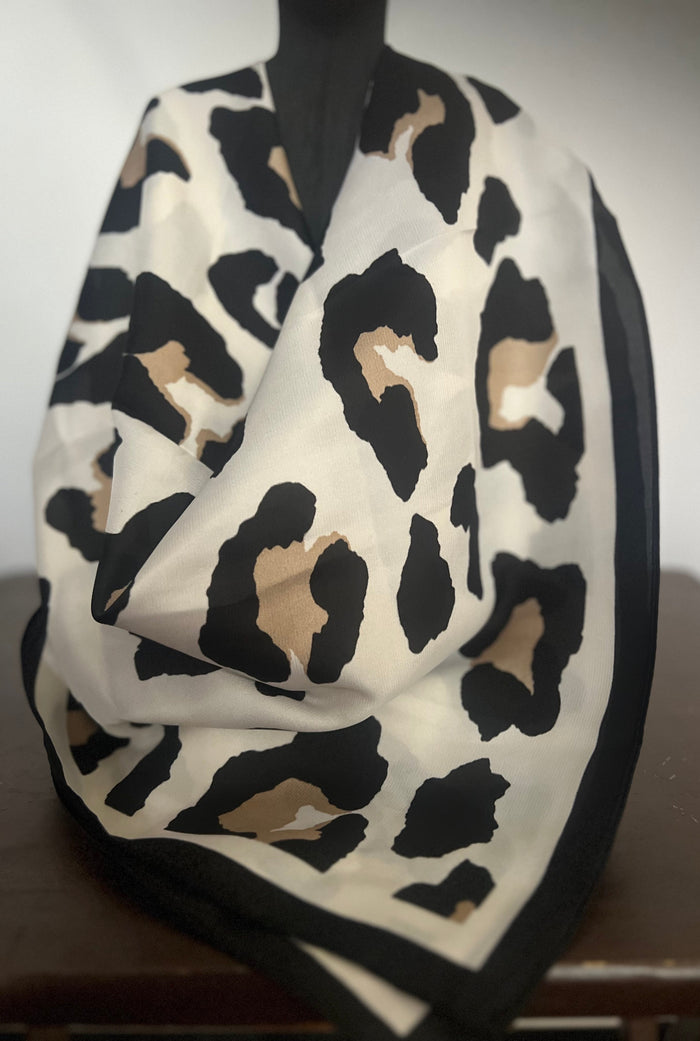 Leopard print scarf on a mannequin against a neutral background